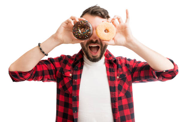 istock Man Covering Eyes With Donuts 1139470601