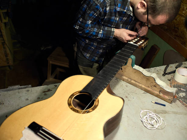 istock In a guitar workshop, Guitars Luthiers sets the strings on a guitar. 1139472950
