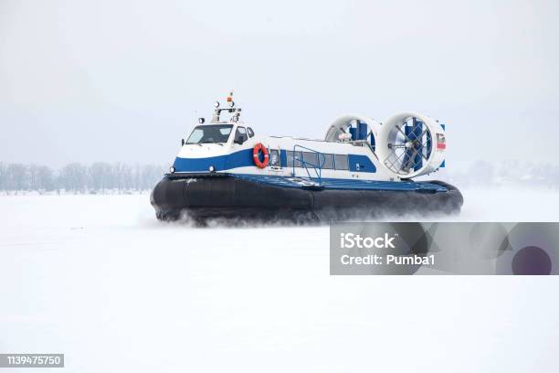 Hovercraft Rushes On A Snowcovered River Stock Photo - Download Image Now - Hovercraft, Amphibious Vehicle, Coastline