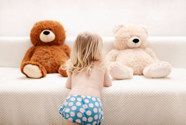 istock Little boy, three years old, plays and eats an apple on the sofa. 1139476849