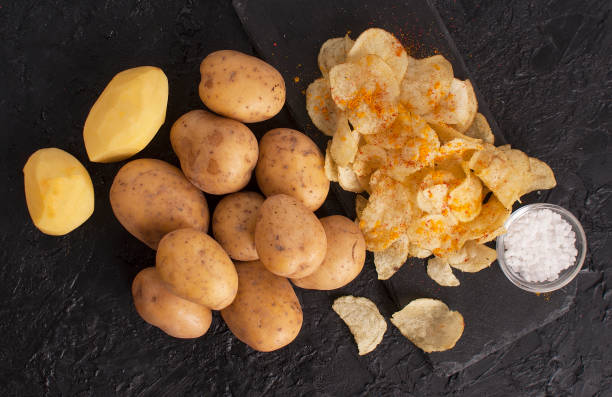 zutaten kartoffelchips auf schwarzem schiefertisch, obere ansicht - potato chip stock-fotos und bilder