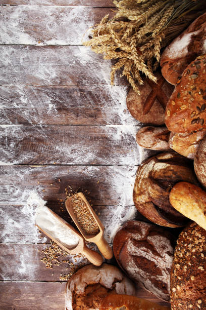 istock Different kinds of bread and bread rolls on board from above. Kitchen or bakery 1139477366