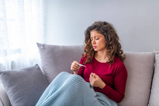 istock Young woman is looking at the thermometer. 1139477371