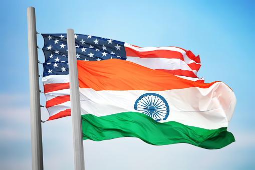 Flags of India and the USA against the background of the blue sky
