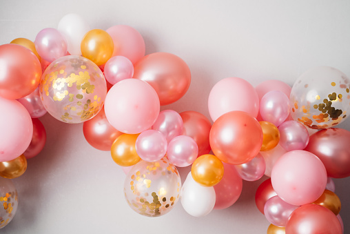 Pink golden balloon garland\nFestive decoration hanging on the wall