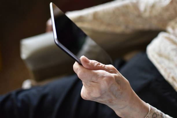 istock Old wrinkled hand holding tablet 1139488145