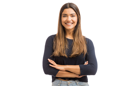 Cute female brunette folding hands while standing over white background