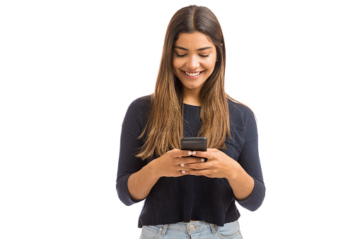 Pretty young woman reaching followers by blogging on smartphone over white background