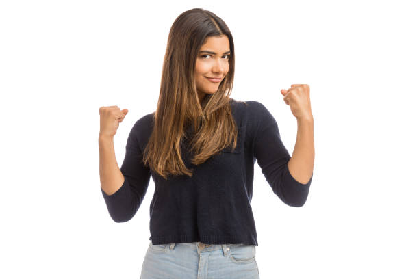 Portrait of confident charming woman showing winning gesture in studio