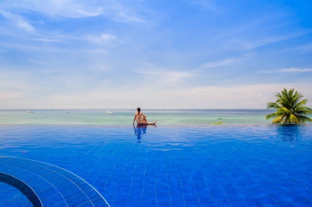istock Young woman sitting on the Infinity pool 1139496899