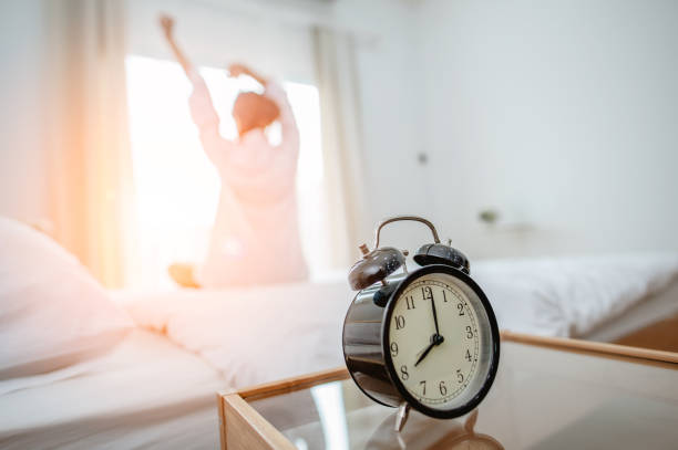 istock Closeup alarm clock  in bed after waking up, sunlight in morning. 1139497940
