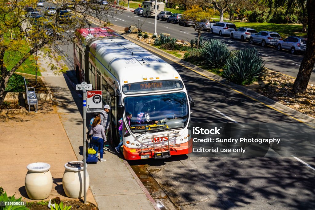 People getting on a bus at Balboa Park stop, San Diego March 19, 2019 San Diego / CA / USA - People getting on a bus at Balboa Park stop San Diego Stock Photo