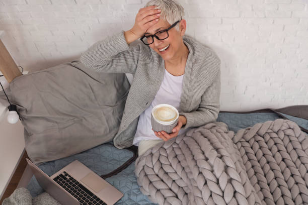 istock Cozy Woman covered with soft woolen blanket, relaxing at home,drinking cacao, using laptop. 1139506456