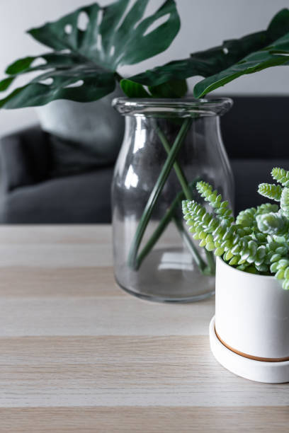 istock Close up composition artificial plant in white ceramic marble paint pattern pot  on wooden top / living room / cozy interior concept 1139510825