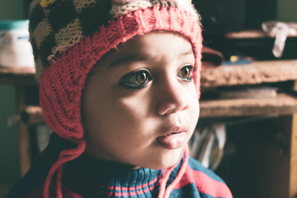 small Indian boy wearing winter cloths indoor shoot looking away
