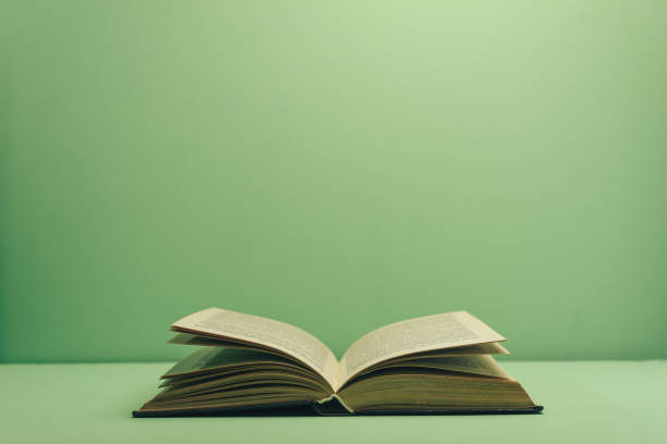 istock Open book on  a green table and background. 1139515353