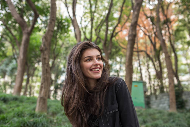 istock Cute young woman sitting at the park 1139520428