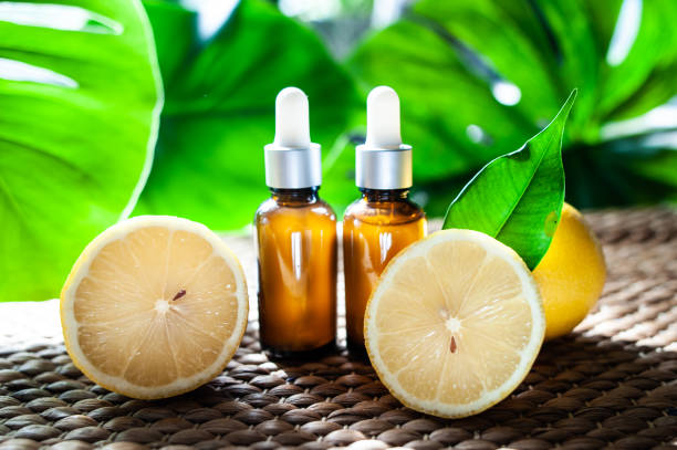 istock Bottles with lemon oil, fresh  fruit whole and half on a natural tropical background. 1139522343