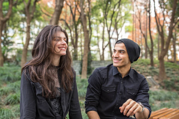 istock Young couple sitting on a park bench 1139522532