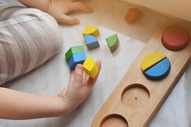 istock The boy arranges geometric wooden figures. Concept education. 1139529165