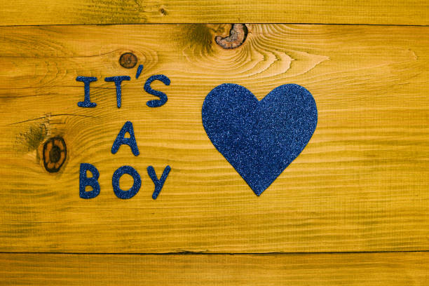 Text it's a boy and heart shape on wooden table.Toned photo.