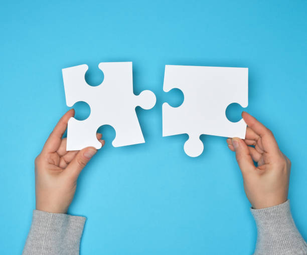 istock two female hands holding big paper white blank puzzles 1139532977