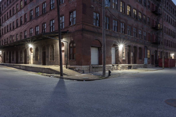 istock Corner of a large red brick vintage multiple story warehouse with lights 1139534225