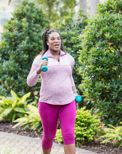 istock Pregnant woman exercising, powerwalk with hand weights 1139534318