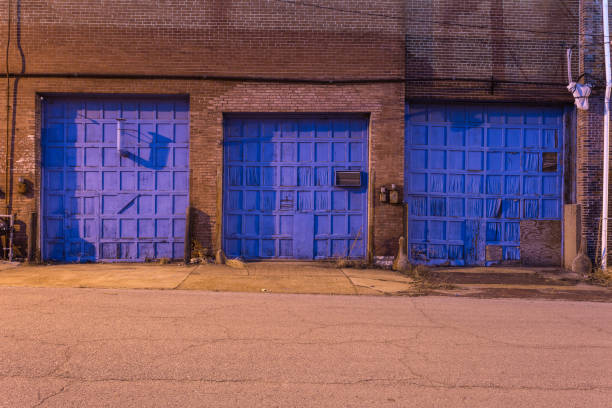 istock Three blue doors on a vintage red brick industrial warehouse in a depressed urban area 1139534321