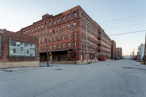Large multiple story vintage red brick industrial warehouse ready for development in a depressed urban area