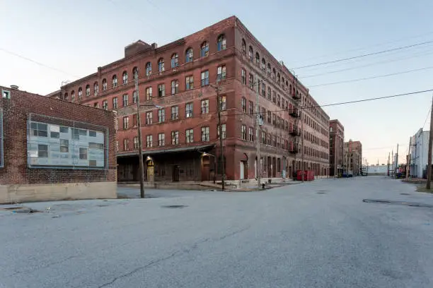 Photo of Large multiple story vintage red brick industrial warehouse ready for development in a depressed urban area