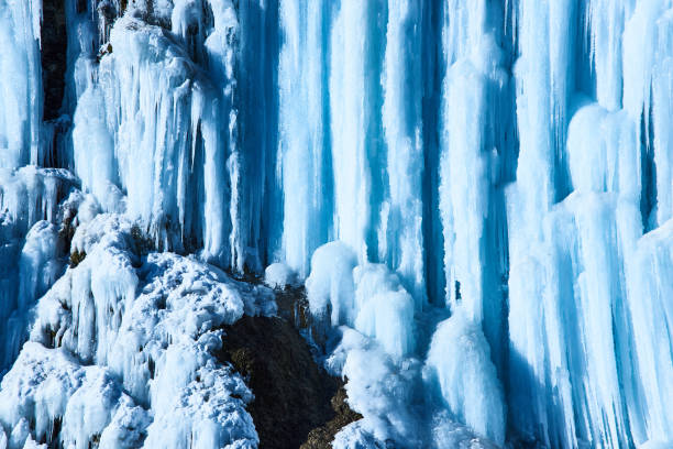 istock Large icicles hang from river bank cliff. 1139534399
