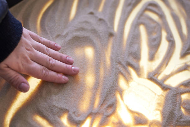 istock The girl's hand draws on the sand 1139535604