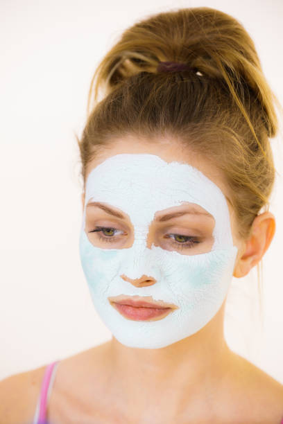 istock Girl with green mud mask on face 1139535608