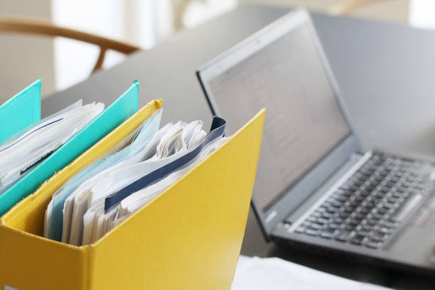 istock Ring binders  filled with papers in front of laptop computer on table in office space. Selective focus 1139537999