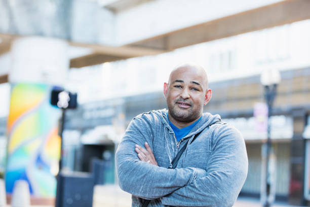 istock Hispanic man with shaved head standing in city 1139539301