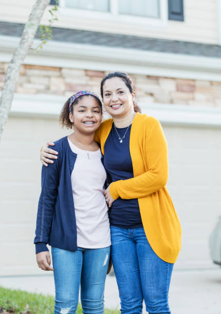 istock Hispanic mother, mixed race daughter in front yard 1139540355