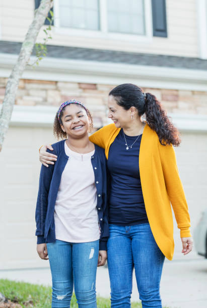 istock Hispanic mother, mixed race daughter in front yard 1139540383
