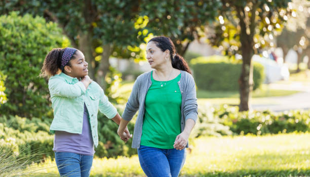 mother and daughter taking a walk, holding hands - spring happiness women latin american and hispanic ethnicity imagens e fotografias de stock