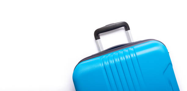 istock Blue suitcase on white background Creative Summer holidays, vacation, travel concept Banner 1139540846