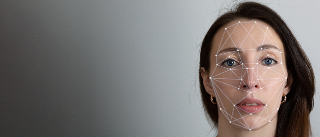 Facial recognition system, concept. Young woman on the grey background, face recognition