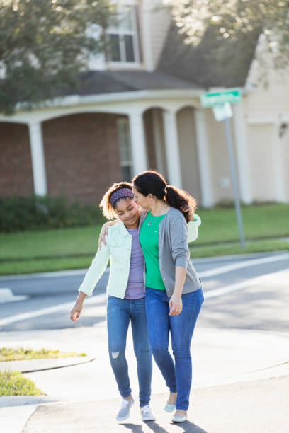 madre e hija caminando juntas - familia de cruzar la calle fotografías e imágenes de stock
