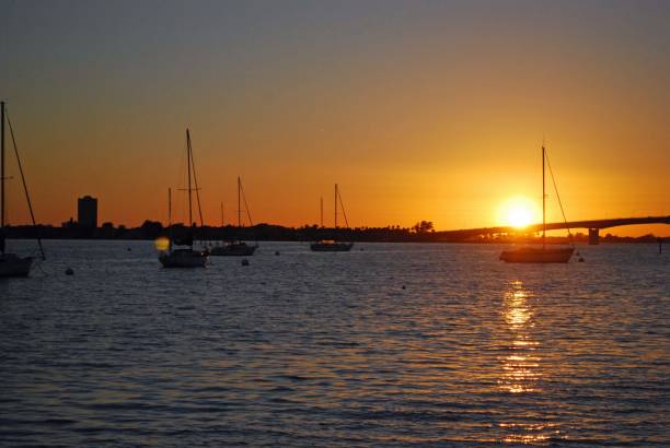 die sonne geht über der john ringling bridge in sarasota florida unter - sailboat sunset nautical vessel sun stock-fotos und bilder