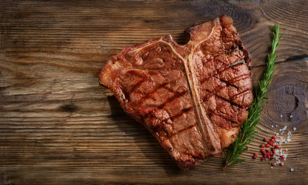 Porterhouse beef steak Porterhouse beef steak cooked on a grill on a wooden Board. Top view porterhouse steak stock pictures, royalty-free photos & images