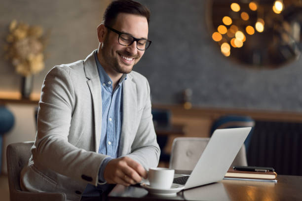 istock Happy businessman using laptop in a cafe. 1139550953