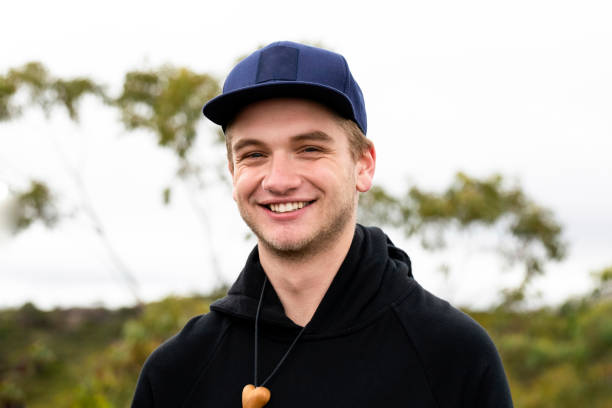 Portrait of smiling handsome young man with cap, backgroun with copy space stock photo