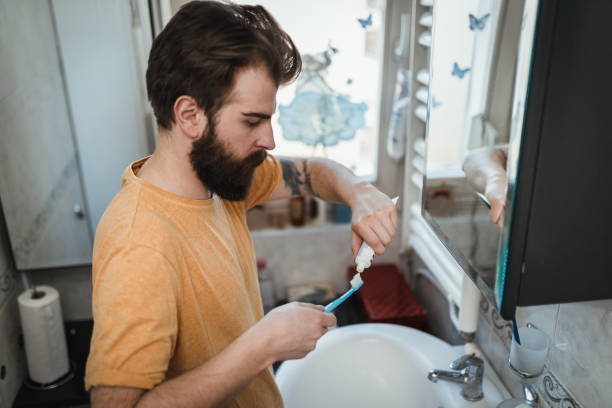 istock Man in pajamas applying toothpaste on the toothbrush 1139561184