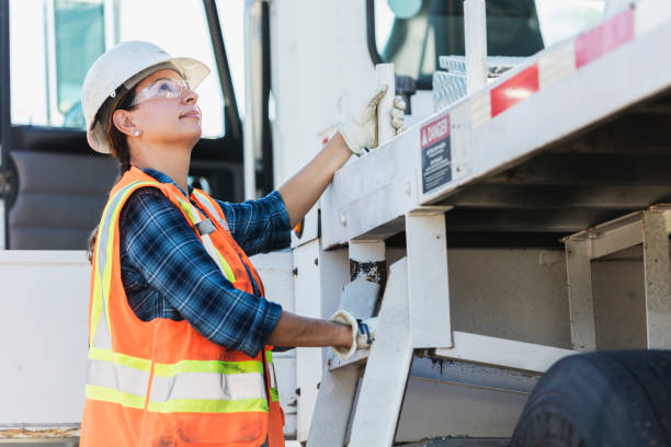 Female crane operator climbing on vehicle
