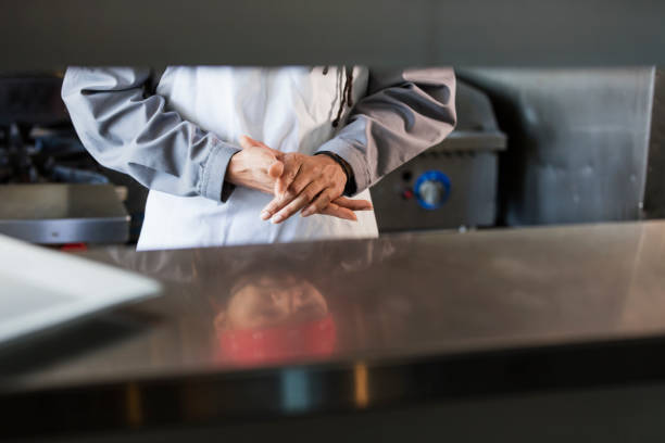 Latin American cook washing the dishes in a commercial kitchen - food service occupation concepts