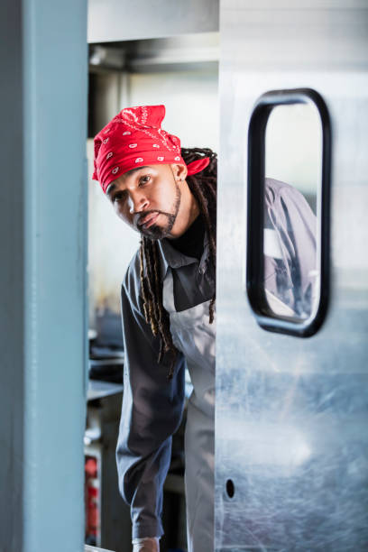 istock Mixed race man with dreadlocks in commercial kitchen 1139564830